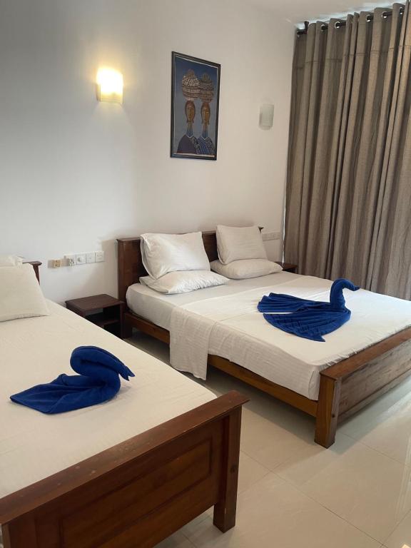duas toalhas azuis em duas camas num quarto em Walaw watta resort em Mirissa