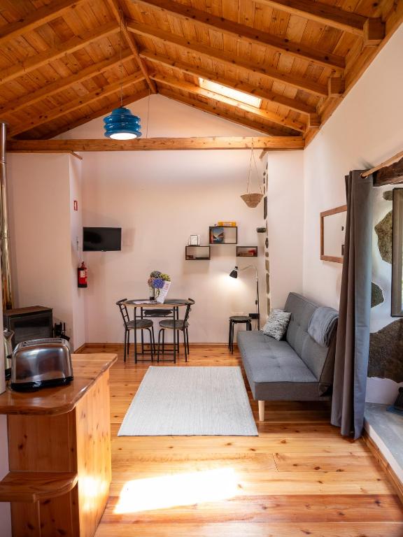 a living room with a couch and a table at Casa Rosa - Casas Florescer in Fajazinha