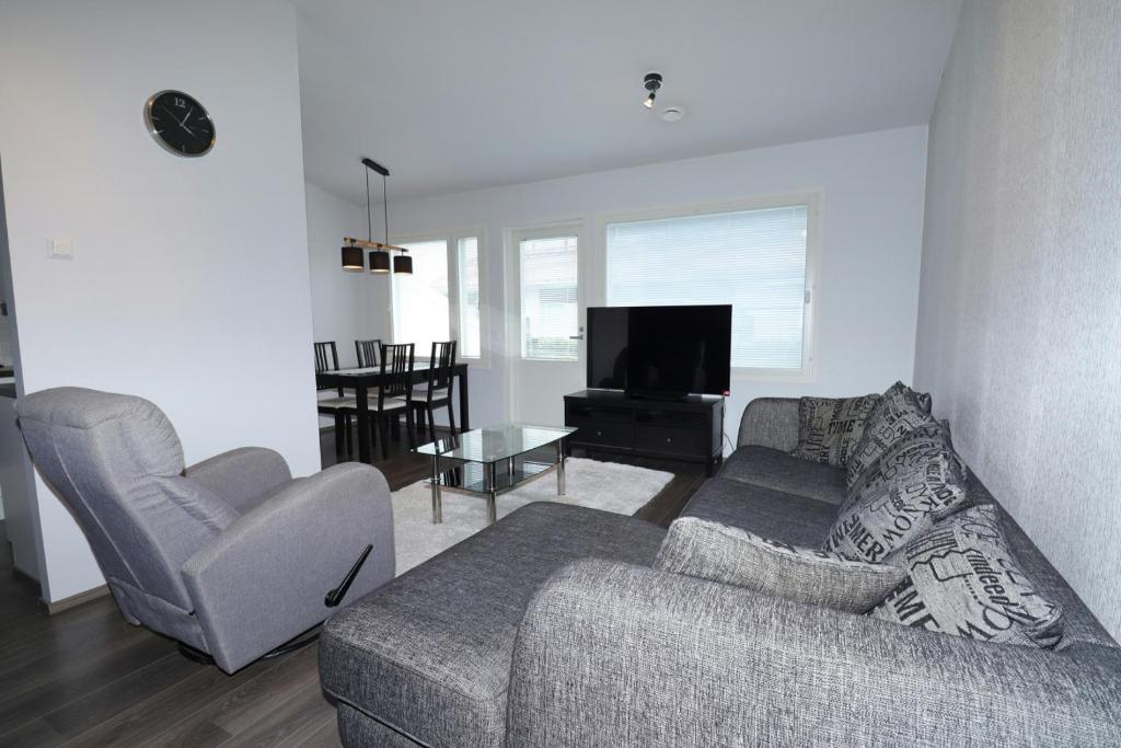 a living room with a couch and two chairs and a television at Convenient Apartment for 2 with Sauna in Pori
