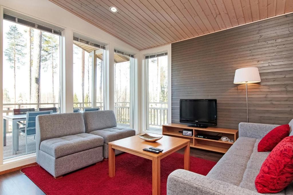 een woonkamer met twee banken en een tv bij Spacious Apartment for 6 with Sauna in Harviala