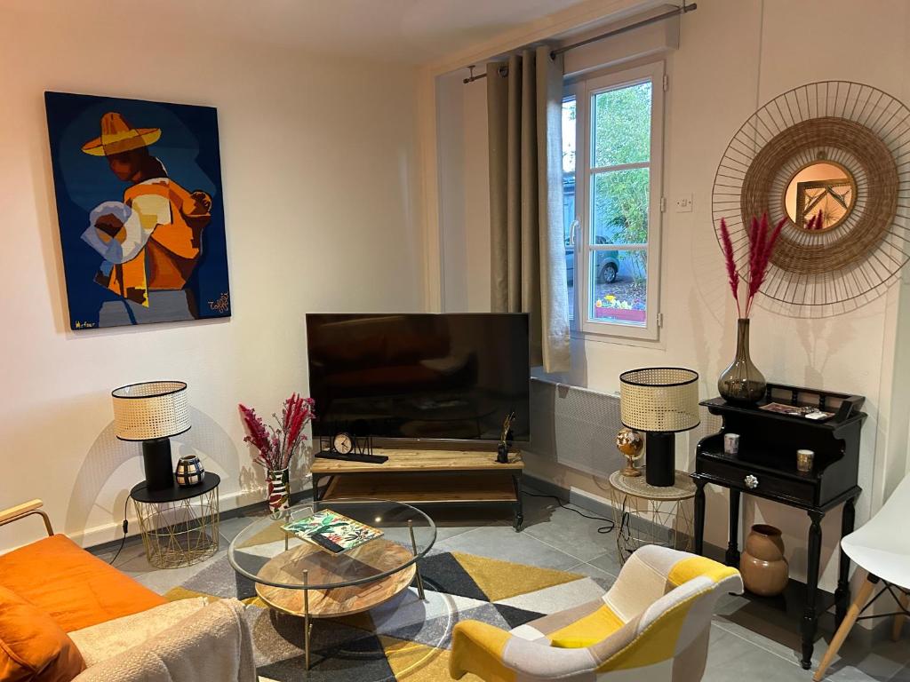 a living room with a couch and a tv at Grand studio refait à neuf in Vierzon