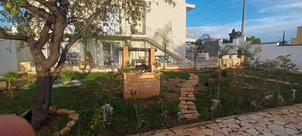 una casa con un árbol y un camino de piedra en L'Arco sul Mare, en Porto Cesareo
