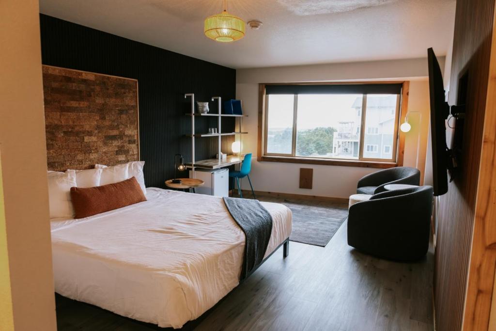 Un dormitorio con una cama y una silla y una ventana. en Adrift Hotel, en Long Beach