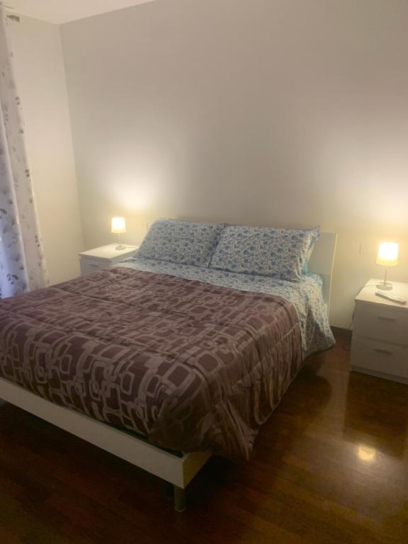 ein Schlafzimmer mit einem Bett mit zwei Nachttischen und zwei Lampen in der Unterkunft Casa Niky 