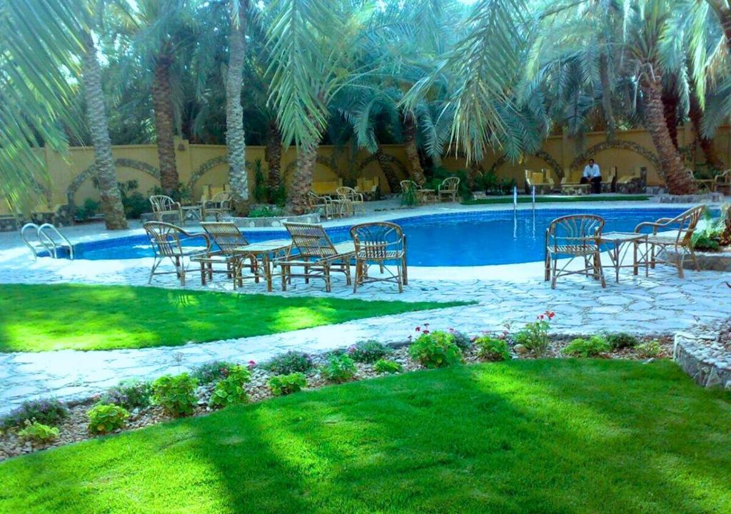 un grupo de sillas y mesas frente a una piscina en Siwa Safari Paradise Hotel, en Siwa