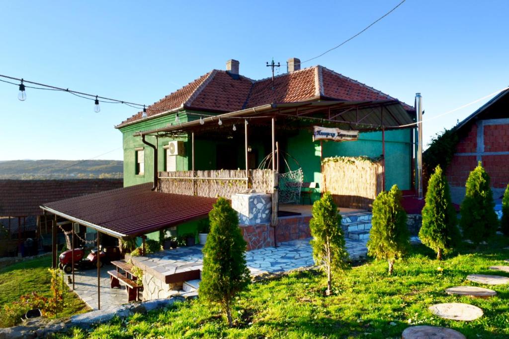 Izvorski Horizonti的绿色房子,设有门廊和庭院