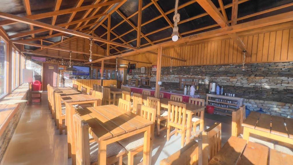 a dining room with wooden tables and chairs at Kalinchowk Tripura Resort in Dhulikhel