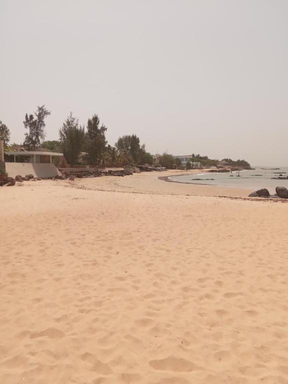 a sandy beach with a view of the ocean at Chez André Léon in Ngaparou