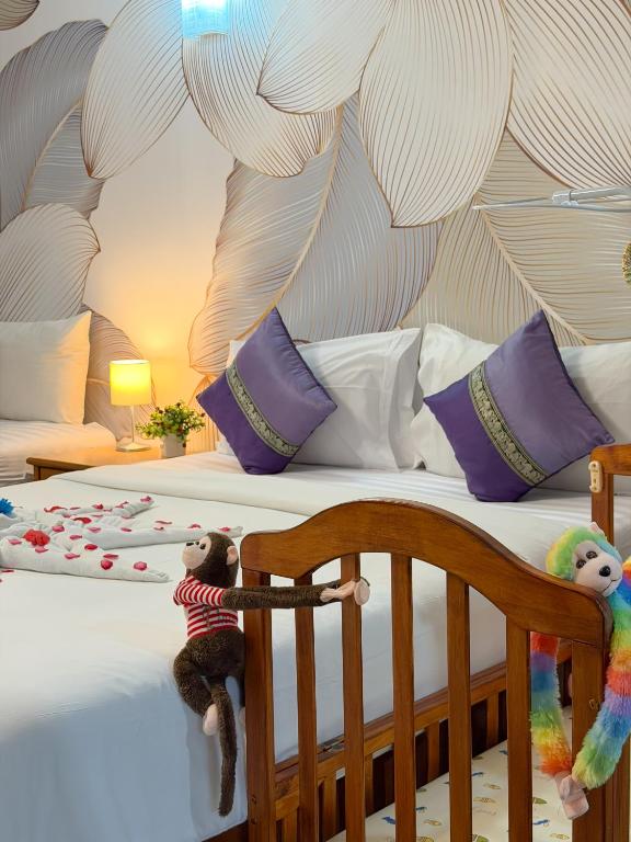 two stuffed animals are sitting on a bed at Chongkhao Resort- Phi Phi Island in Phi Phi Islands