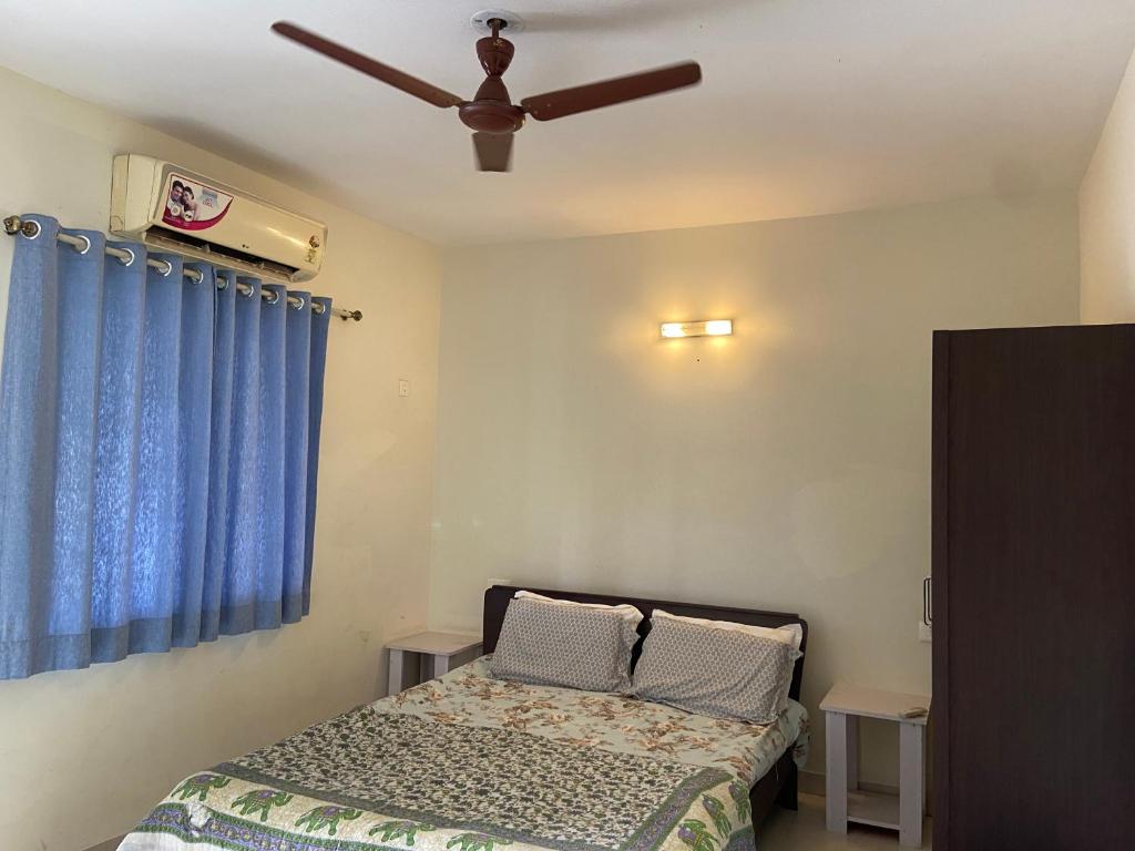 a bedroom with a bed and a ceiling fan at Candolim Sea Breez in Candolim