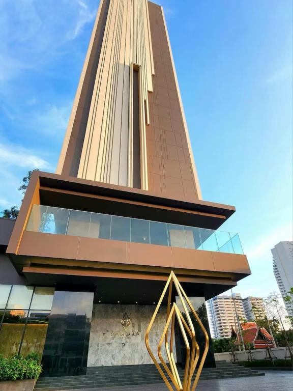 ein hohes Gebäude mit einer goldenen Skulptur davor in der Unterkunft The Panora Pattaya Top Luxury Seaview Condo in Pattaya South
