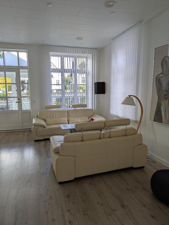 a living room with two couches and a table at Den gamle stenhugger in Haderslev