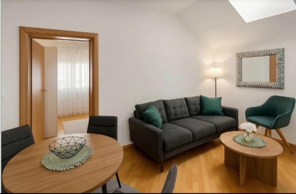 a living room with a couch and a table at ZARA apartment- Near the Old town , 3 ACs , Free Parking, Peaceful in Mostar