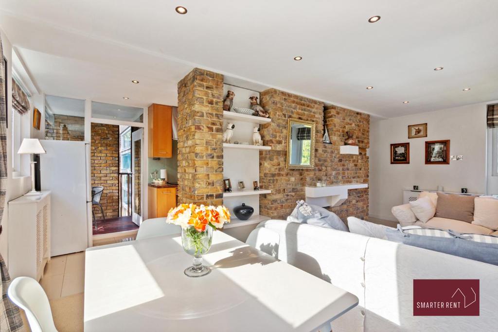 a living room with a white couch and a brick wall at Richmond Three Bedroom Flat in Whitton