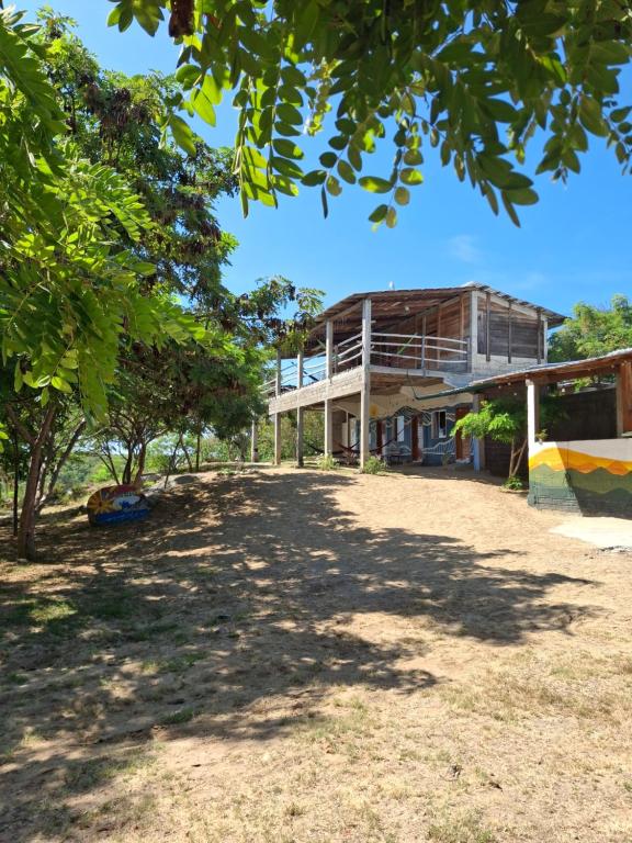 Barra de la CruzEl Cielo Hostel的前景中树木的建筑物的图像