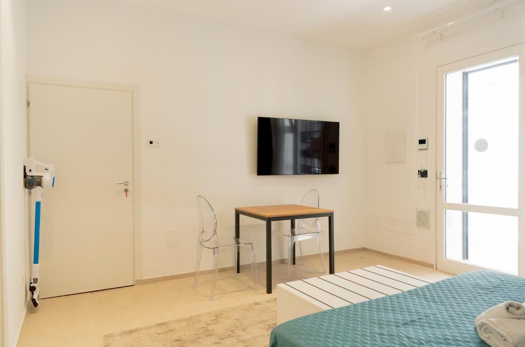 ein Schlafzimmer mit einem Tisch und einem TV an der Wand in der Unterkunft Cielo D'Alcamo Palazzo Oliva in Alcamo