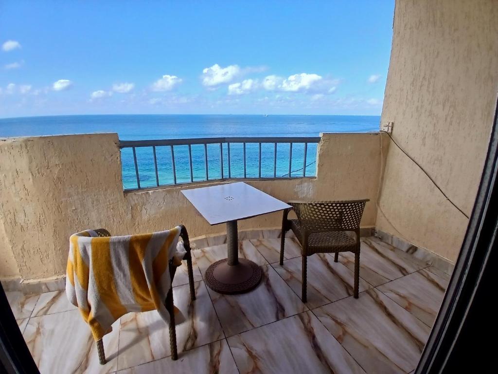 アレクサンドリアにあるFlores casas de playaのテーブルと椅子と海のあるバルコニー