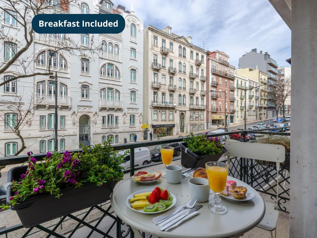a table with food and drinks on a balcony at LX51 Studios & Suites by APT IIN - Lisbon Center in Lisbon