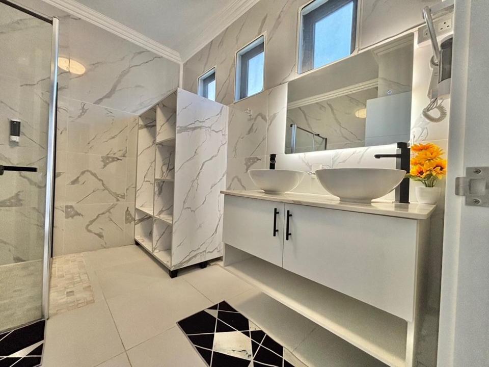 a white bathroom with two sinks and a shower at Mont Oreb Villas Ambre Flic en Flac in Midlands Station