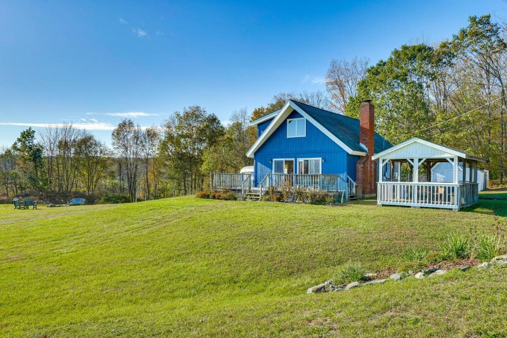 una casa azul en un gran campo de hierba en Relaxation Meets Upstate Adventure at Salem Home!, en Rupert
