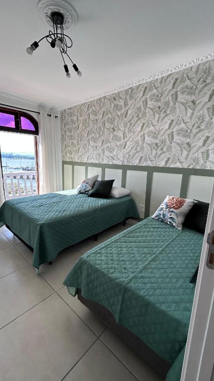 a bedroom with two beds and a window at Mirante Luz Floripa in Florianópolis