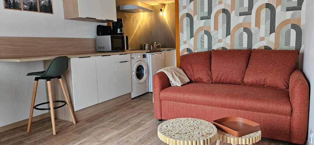 QuiéIsard - Le Hameau De La Courbière的带红色沙发的客厅和厨房