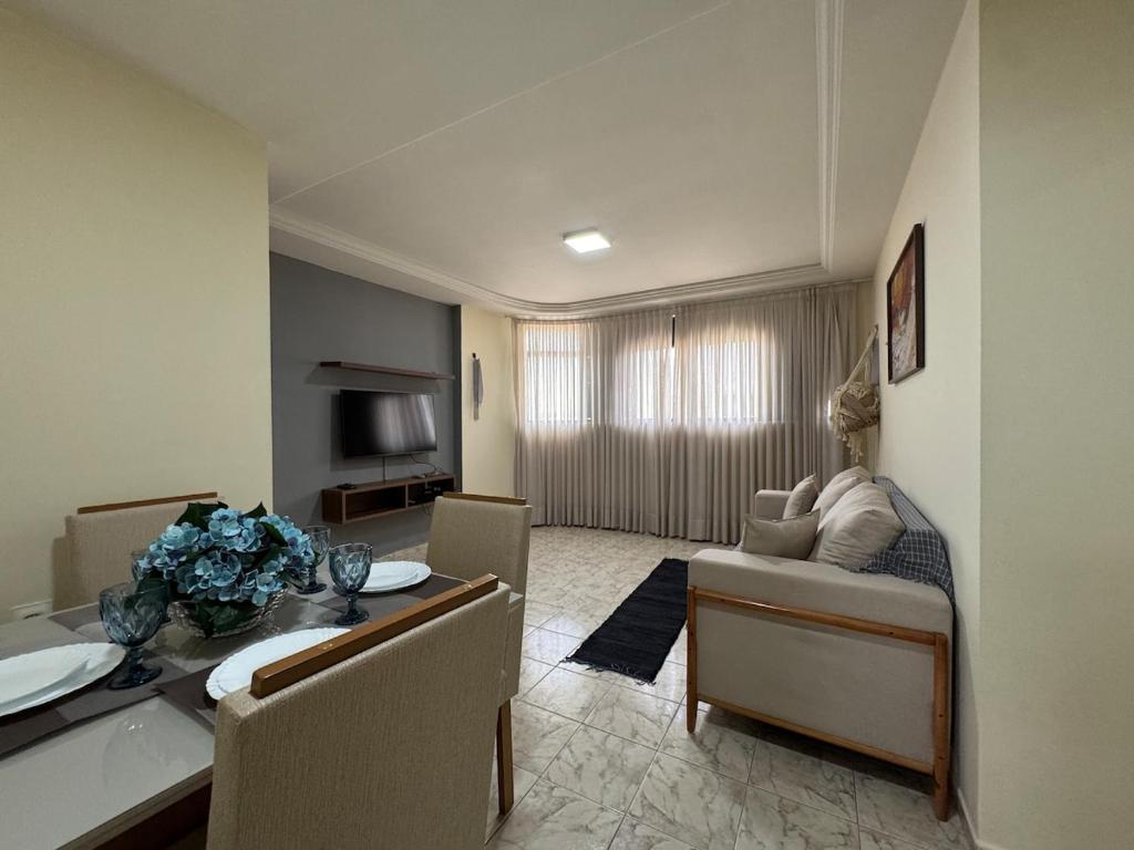 a living room with a couch and a dining room at Conforto e espaço garantido no Bessa in Nossa Senhora do Livramento