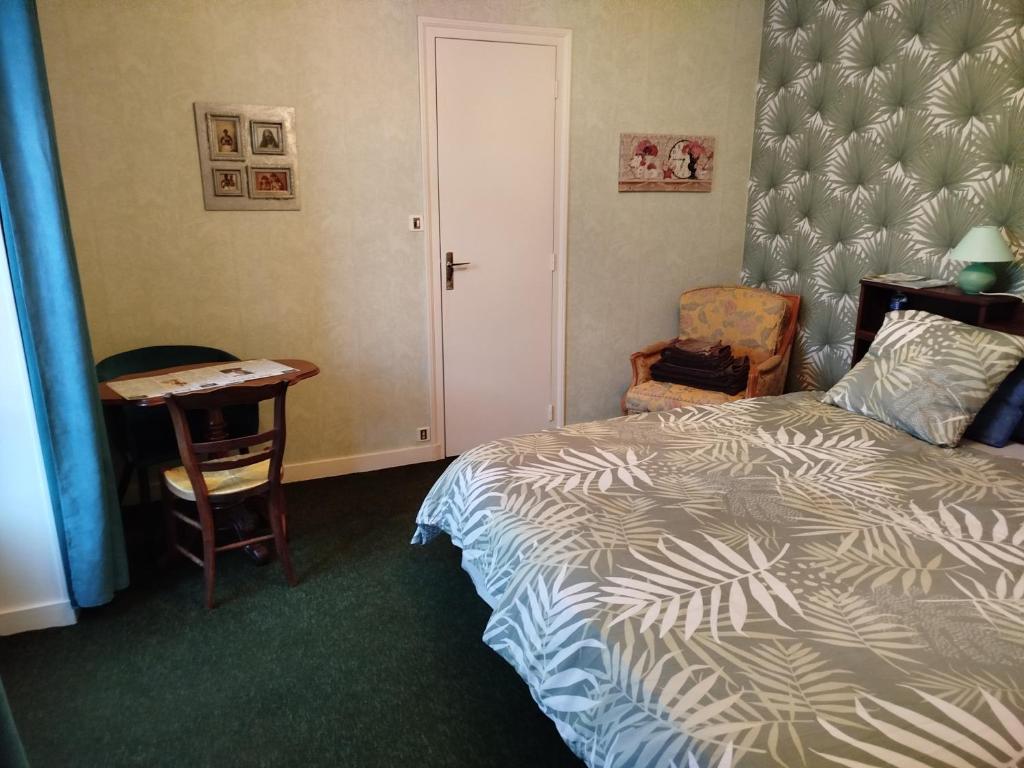 une chambre avec un lit, un bureau et une chaise dans l'établissement Chambre d hôte de la paix, à La Rochefoucauld