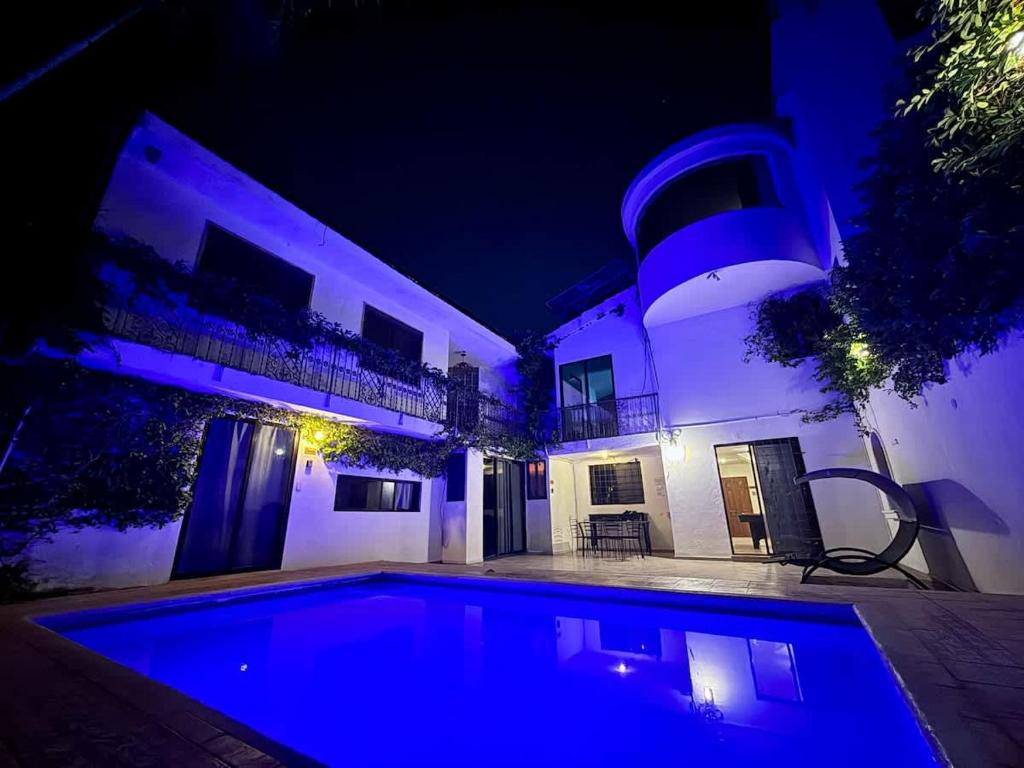 a swimming pool in front of a house at night at Alojamiento para 3 personas con alberca y billar in Chuburná de Hidalgo