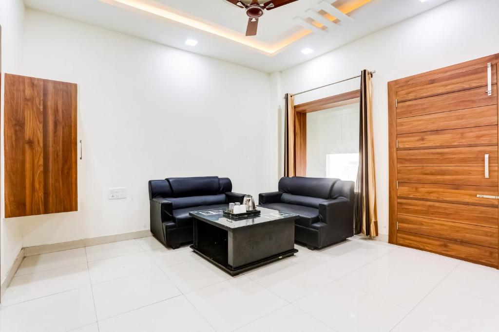 Una sala de estar con dos sillas y una mesa. en Super Hotel O Green, en Hisār