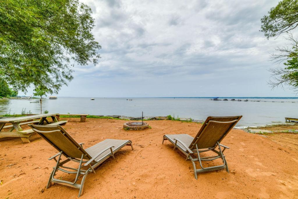 two chairs sitting on a sandy beach near the water at House on Oneida Lake on Lewis Point in Canastota in Canastota