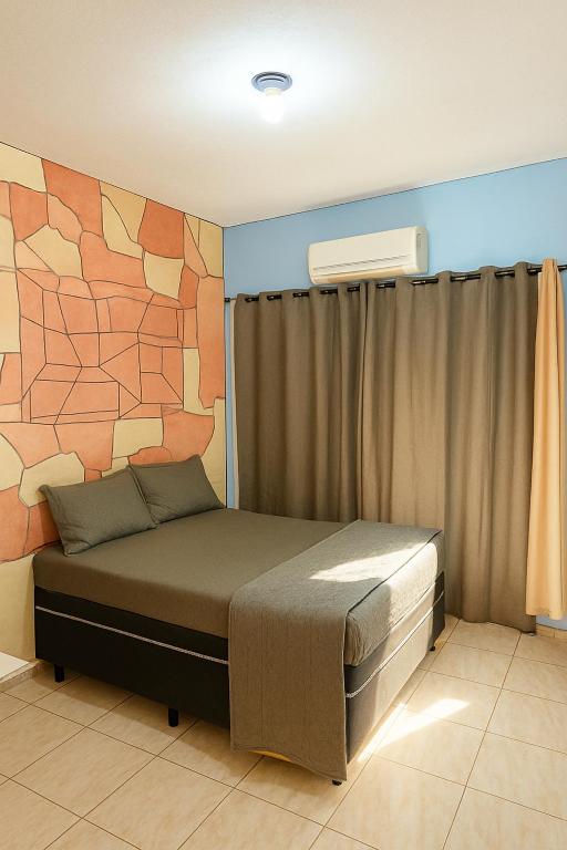 a bedroom with a large bed with a stone wall at Air conditioning, TV and free parking - Bathroom in Cuiabá