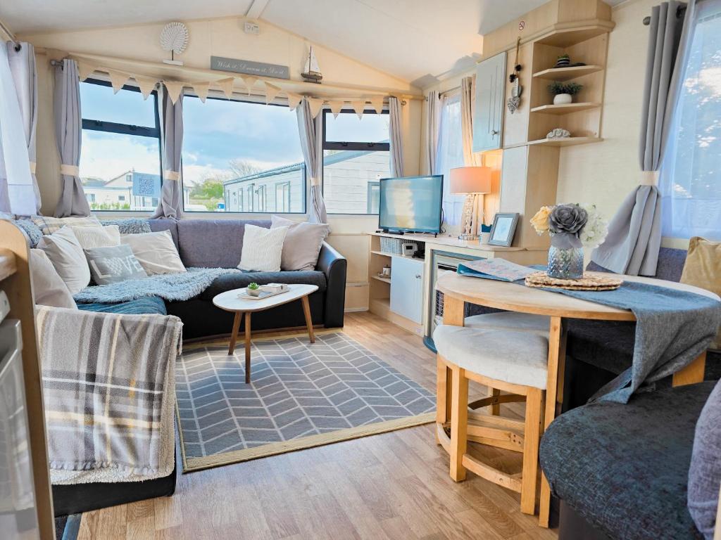 ein Wohnwagen-Wohnzimmer mit Couch und Tisch in der Unterkunft Ocean Breeze in Truro