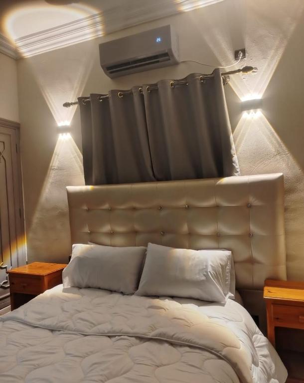 a bedroom with a bed with a curtain above it at hotel and restaurant kasbah draa in Agdz
