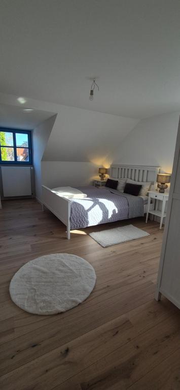 Un dormitorio blanco con una cama y un escritorio. en Altstadt Loog, en Leer