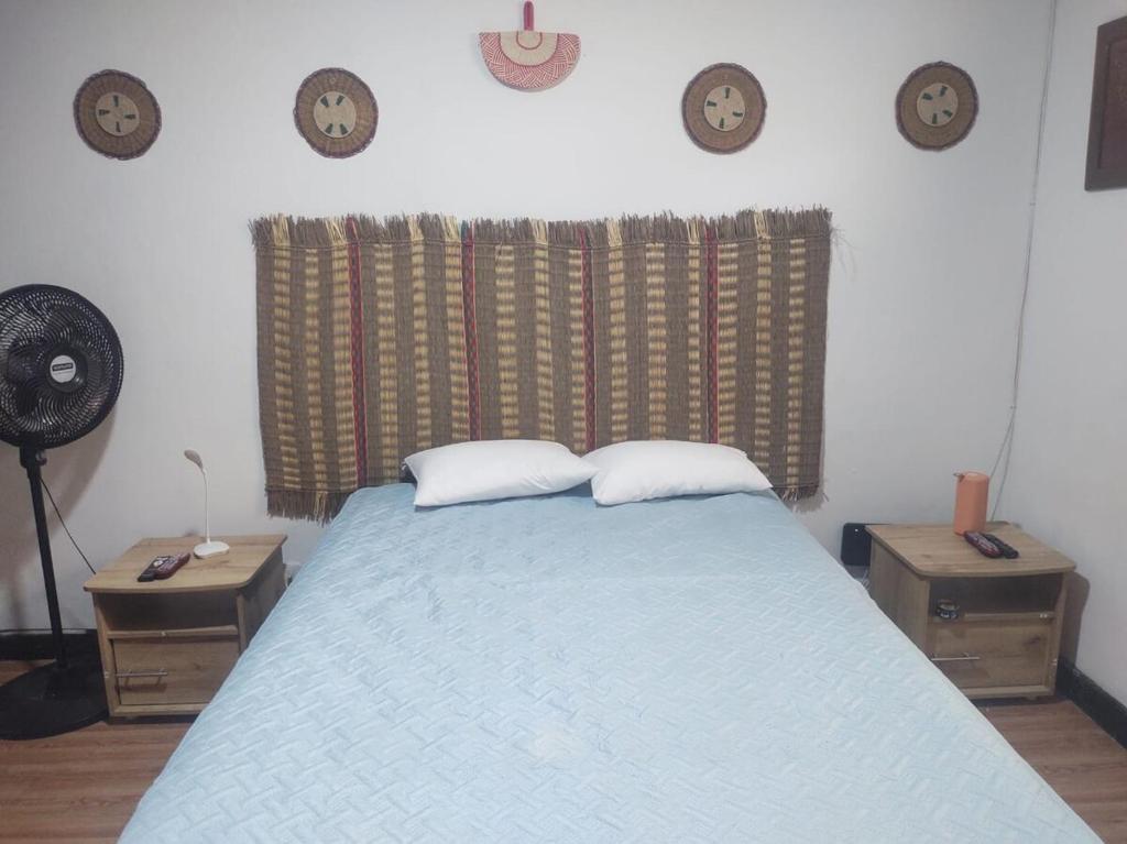 a bedroom with a bed and clocks on the wall at Nina House, Cali, Valle del Cauca in Cali