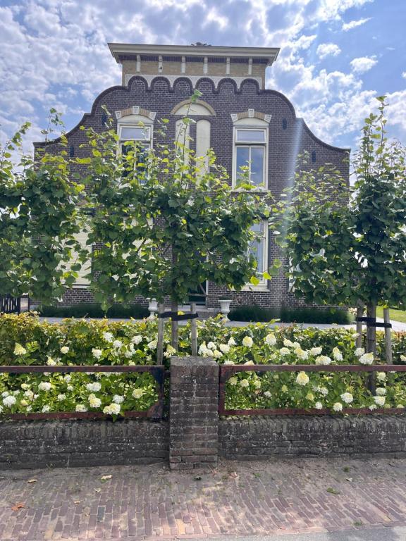 a house with a fence in front of it at Hoeve Herweijer in Strijensas
