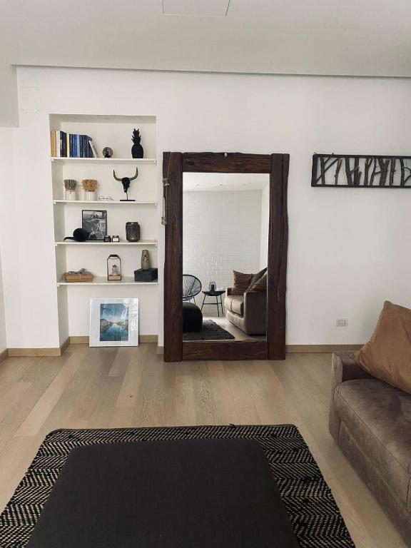a living room with a mirror and a couch at CASA JACK Open Space Piazza Galimberti in Cuneo