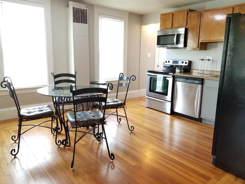 a kitchen with a table and chairs in a room at Bright Front Facing Unit - Private Front Farmers Porch in Manchester
