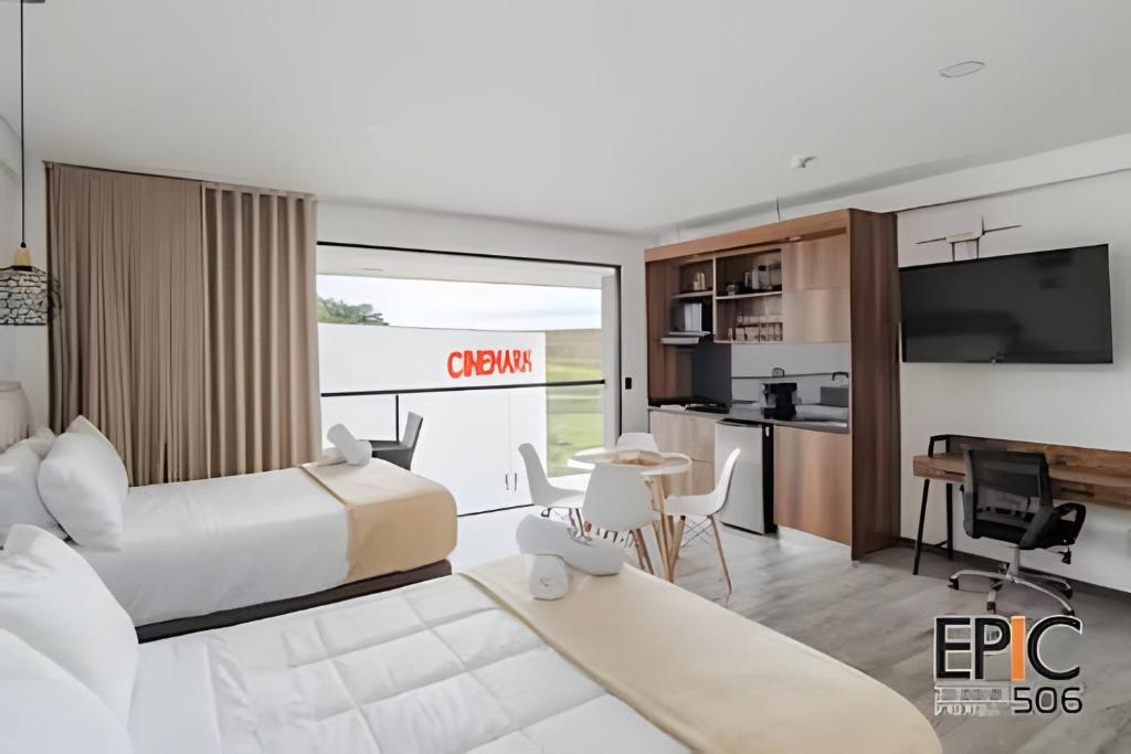 a bedroom with a bed and a kitchen with a desk at Epic Suite 506 Deluxe Aeropuerto in Cuba