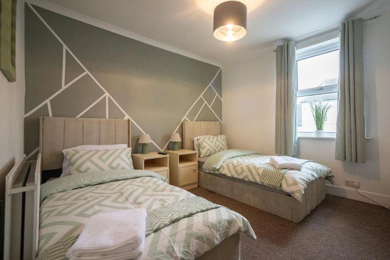 une chambre avec deux lits et une fenêtre dans l'établissement Rochdale Residence, à Royal Tunbridge Wells