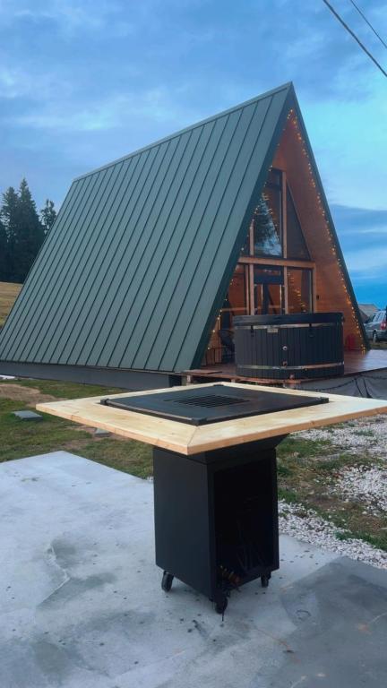 a house with a black roof on top of a table at La Știubei Cabin in Mărişel