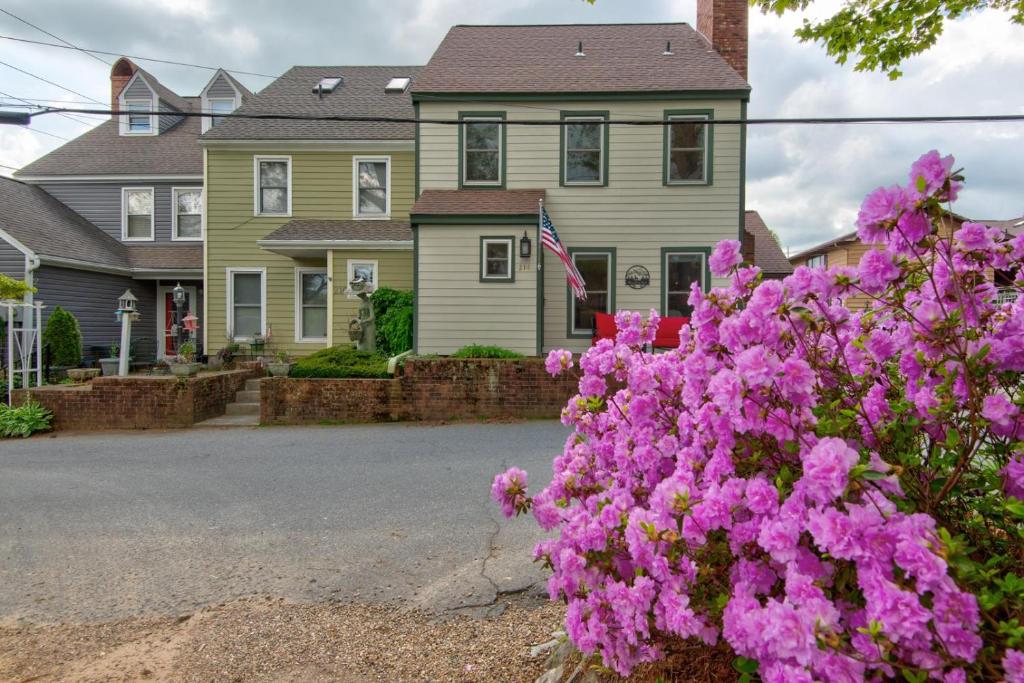 a house with pink flowers in front of a street at The Wander Inn in Blowing Rock