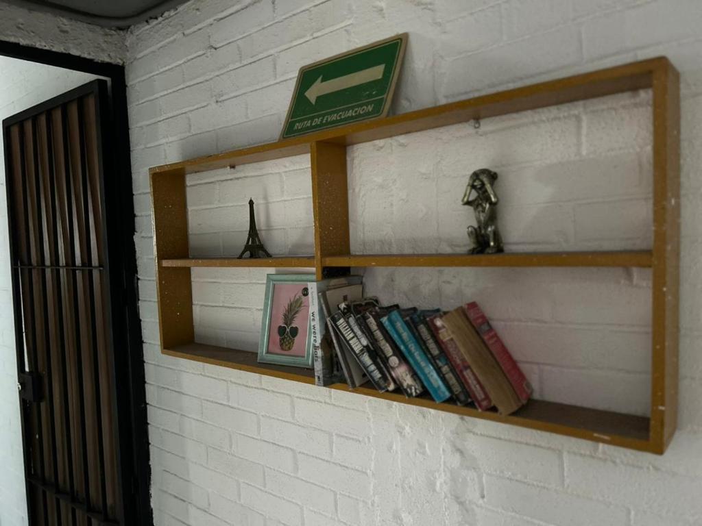 Una estantería en la pared con libros en Canova Hostel & Pizza, en Puerto Vallarta