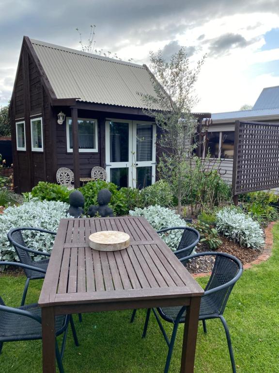 a wooden table and chairs in front of a house at Evermore Stay in Richmond
