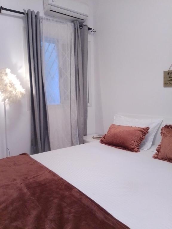 a bedroom with a large white bed and a window at Appartement fun in Dakar