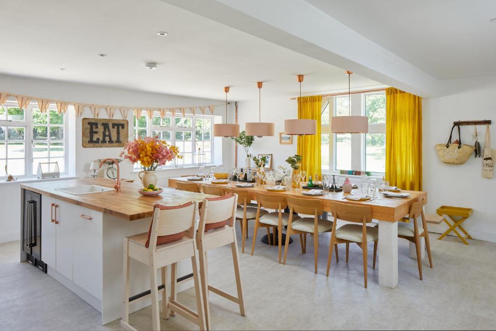 a kitchen and dining room with a table and chairs at Priory Coach House in Pagham