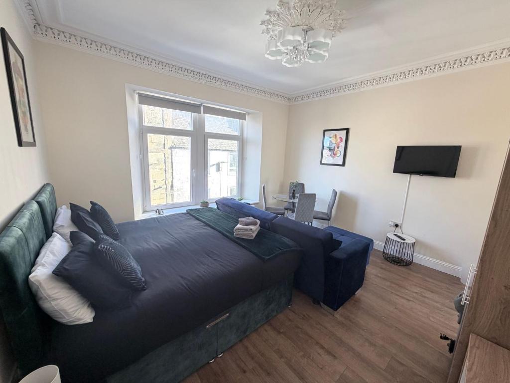 Un dormitorio con una cama azul y un sofá. en Apartment 4- 216 high street, en Arbroath