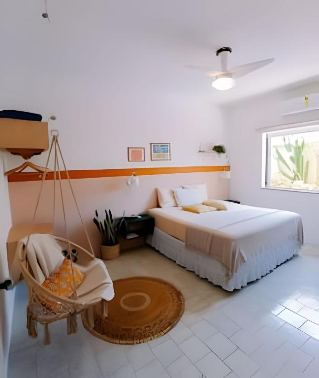 a bedroom with a large bed and a swing at Casa mangarito - suítes in Ubatuba