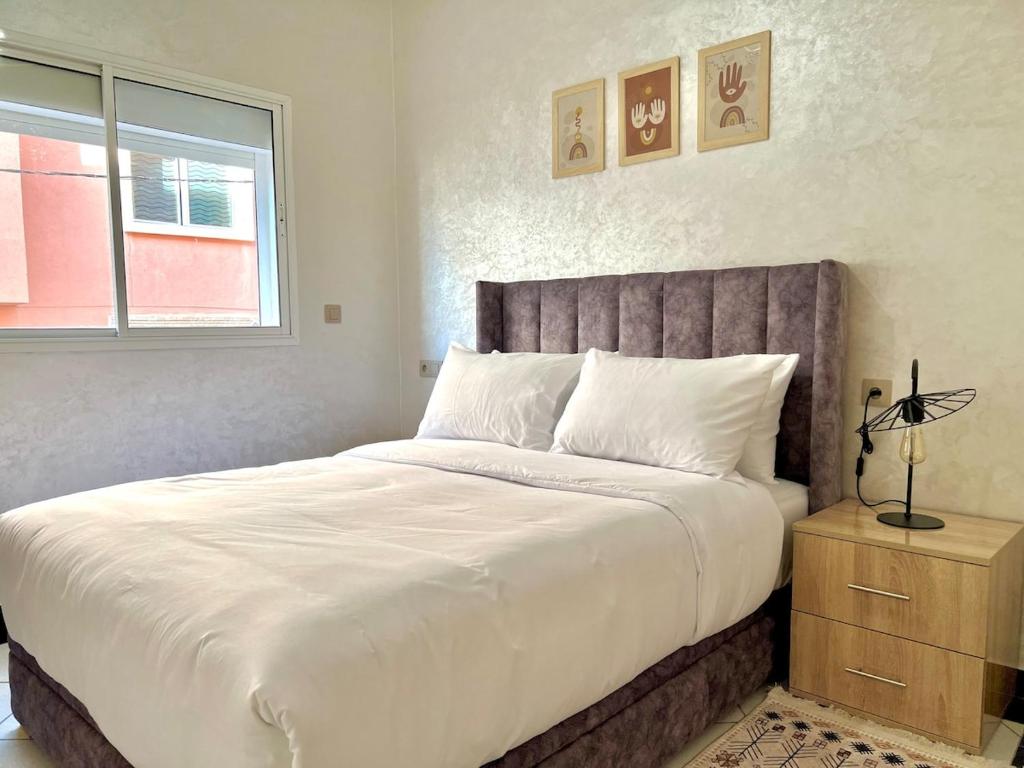 Un dormitorio con una cama grande y una ventana. en A8 Getaway in Tamraght, Fiber Wi-Fi, 5 min to beach, en Tamraght Ouzdar